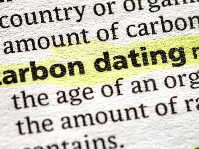 Closed up image of the words carbon dating from a book.