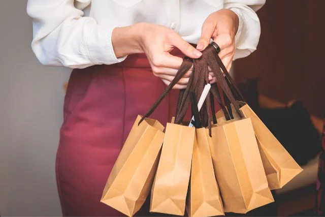 An employee distributing corporate gifts in paper bags.