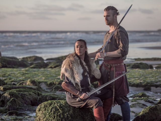 A nordic couple posing on a shore.