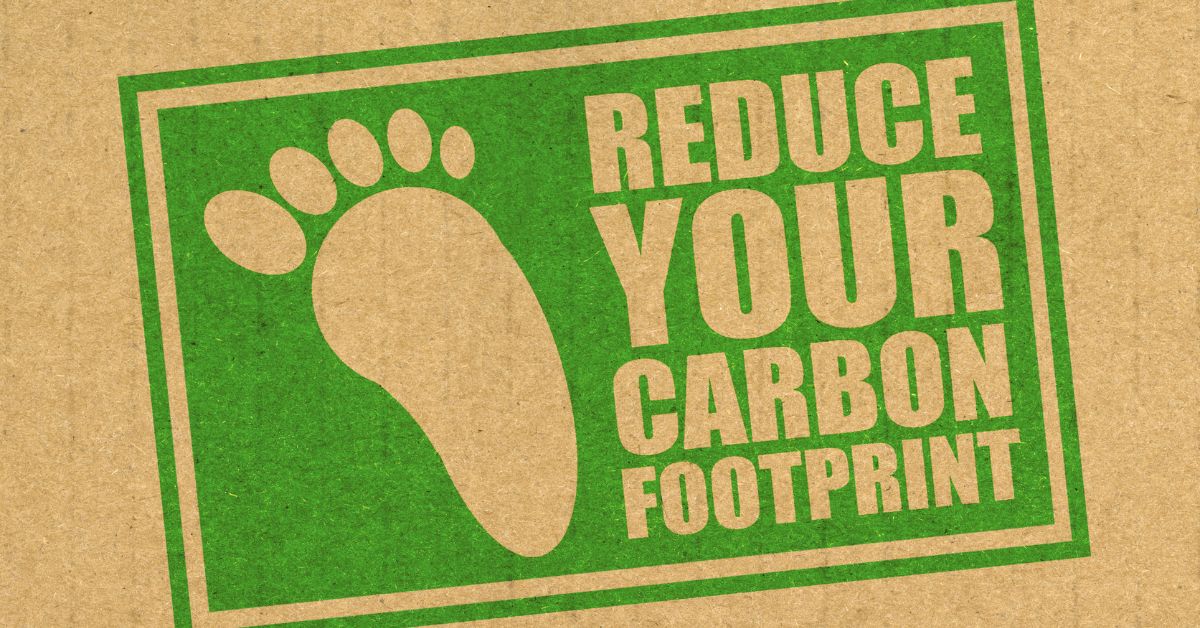 A "Reduce your Carbon Footprint" sign stamped on a brown paper.