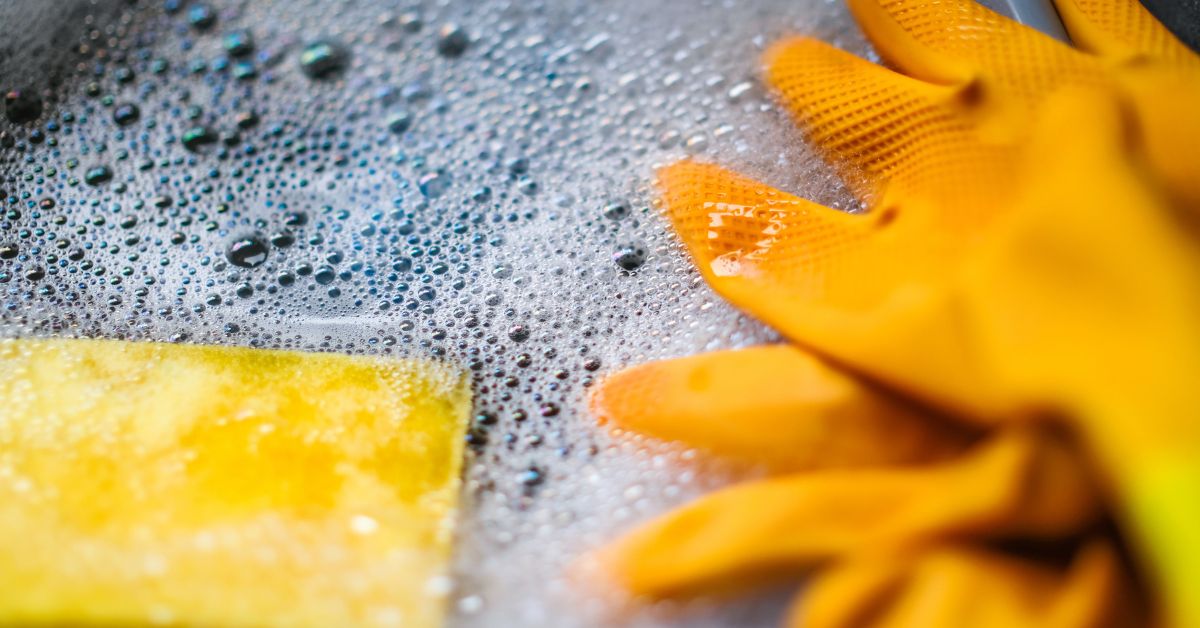 Mild dish soap in a water with a soaked sponge and gloves.